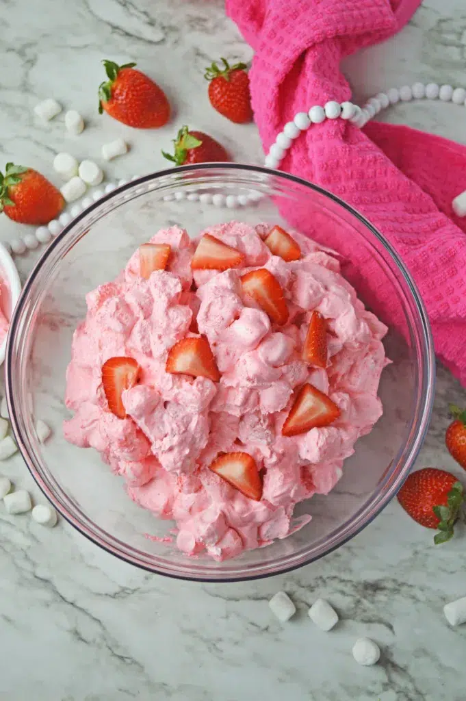 pink strawberry fluff dessert topped with fresh strawberries